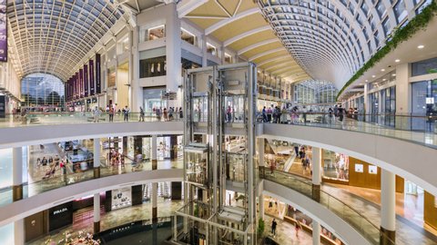 Singapore, Singapore city, 06-15-2019, TL/ time lapse of people inside the Marina Bay Sands Shoppers shopping mall, showing the modern interior design, with people using lifts and escalators