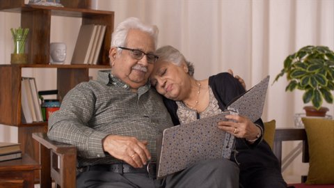 Clip of a romantic moment between an elderly Indian couple. HD video clip of an elderly Indian couple having a romantic moment while going through their wedding album