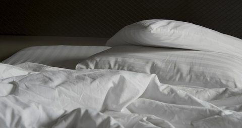 Two pillow and crumpled messy white blanket untidy, Unmade bed after waking up in the morning with a duvet on the bed.