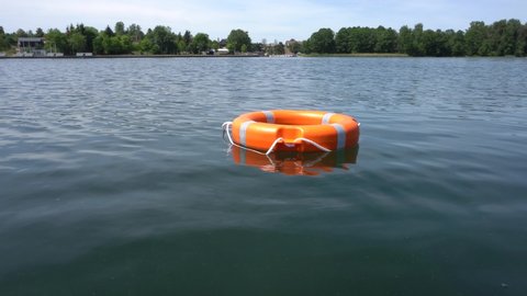Footage of red rescue buoy floating on water surface. This is an emergency. Gimbal motion shot