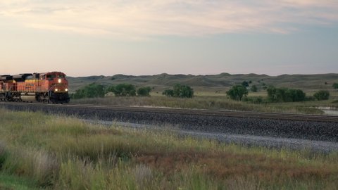 Halsey, NE, USA - September 15, 2019: Empty BNSF coal train running at dawn west to Wyoming through Nebraska Sandhills, early fall scenery.
