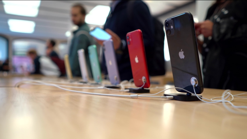 BOLOGNA, ITALY - SEPTEMBER 20, 2019: The new iPhone 11 in different colors displayed inside Apple Store. Selective focus with customers blurred in the background.