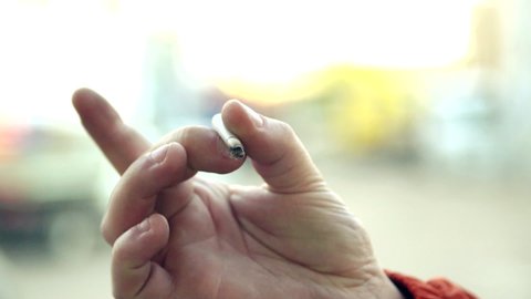 Male hand throws a cigarette butt. A man quits smoking. Selective focus.