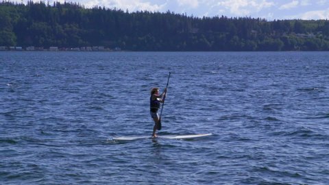 Camano Island , WA / United States - 05 19 2019: Standup Paddle Boarder in Elger Bay
