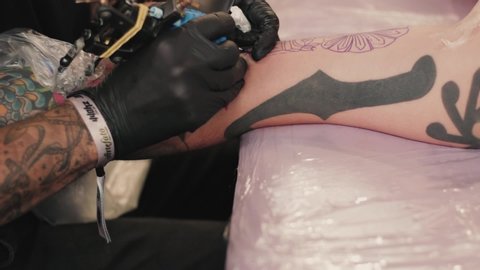 BELO HORIZONTE , MINAS GERAIS / Brazil - 05 18 2019: Professional tattoo artist tracing over tattoo outline on client arm during BH Tattoo festival