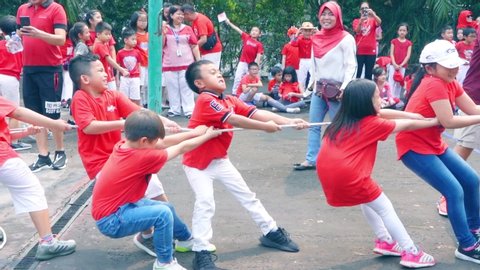 JAKARTA, Indonesia - September 19, 2019: Slow motion of group of children in tug of war game during Indonesia independence day celebration