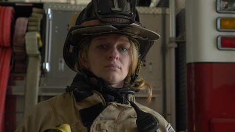 Goose Creek , South Carolina / United States - 02 16 2018: Female firefighter in protective helmet and firefighting coat looks at camera