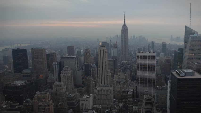 time-lapse view, the sun sets over the skyline in New York City, USA. 