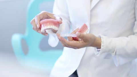 female doctor displaying clear aligner dental appliance