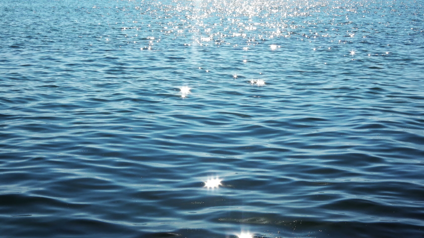 Too many shiny reflections of the sun in the water. It's a close-up shot of the ocean with small ripples on a sunny day. Royalty-Free Stock Footage #1037573822