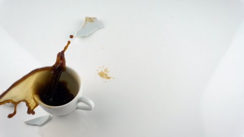 The concept of destruction with copy space. Falling and breaking cup of coffee in slow motion.