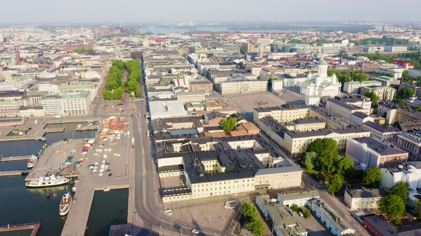 Helsinki, Finland. Helsinki Cathedral dominates the northern edge of Senate Square with its bright white neoclassical facade, green copper dome rising over 80 meters, and symmetrical Greek cross plan. The aerial view captures the cathedral