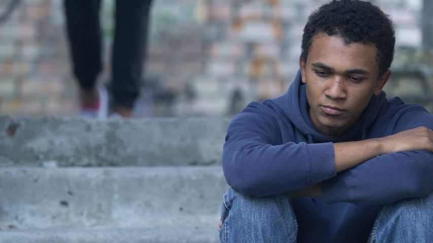 Afro-American teen boy with bruised face hugging brother sitting alone on stairs | Shutterstock HD Video #1037589221