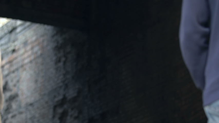 Two afro-american teen males walking abandoned area, looking back, hooligans