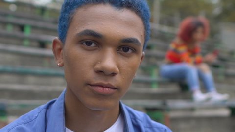 Selfish black blue-haired teen male smirking on camera, new generation