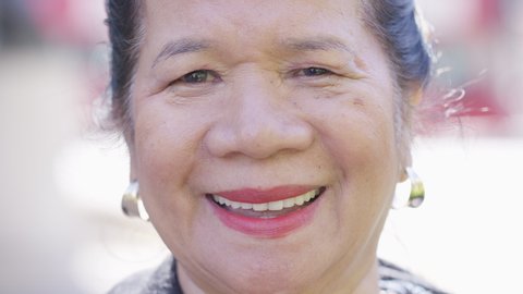 Portrait of attractive elderly Filipino female looking and smiling to camera 