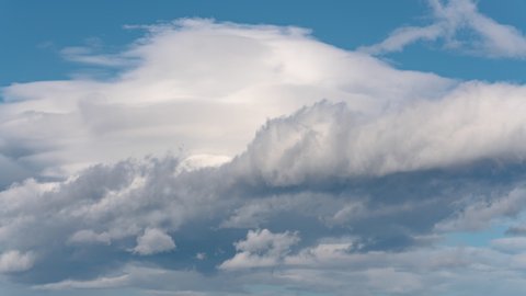 Beautiful cloudscape, dramatic cumulus clouds floating across blue sky to weather change. Motion blur clouds in heaven. Natural meteorology background on summer sunny day. 4K environment time lapse.