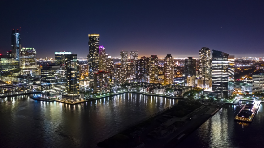 Night Jersey City hyperlapse with panning and rotation motion, above Hudson river, in front of the city skyline