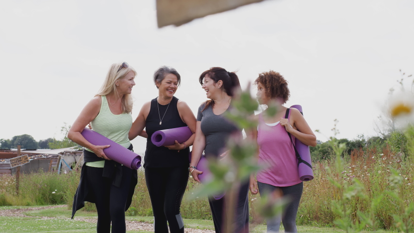 Group Of Mature Female Friends On Outdoor Yoga Retreat Walking Along Path Through Campsite Royalty-Free Stock Footage #1037640230