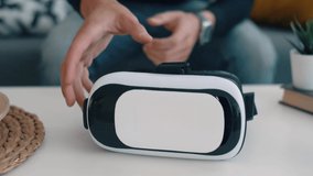 Man hand take vr glasses from coffee table in living room. slow motion footage.
