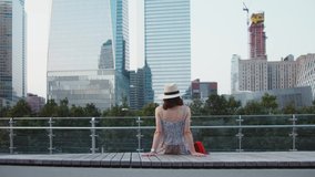 Young girl in a hat in front of skyscrapers