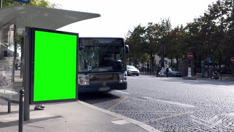 Green screen on the side of a bus stop in a city center (Denfer-rochereau, Paris)