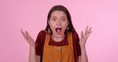 Excited teenage girl on light pink background