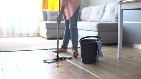 Barefoot girl mopping floor, maintaining cleanliness and hygiene in house, tips