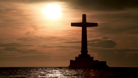 Sunset behind a large memorial cross on a tropical island (Sunken Cemetery, Camiguin, Philippines)