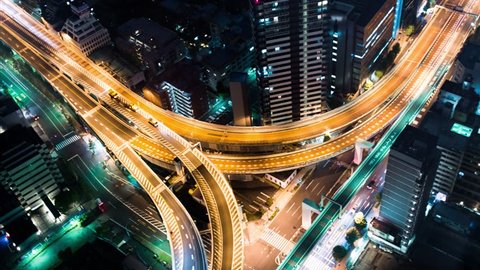 Multi-hour aerial view time-lapse of a massive highway intersection at night in Shinjuku, Tokyo, Japan.
