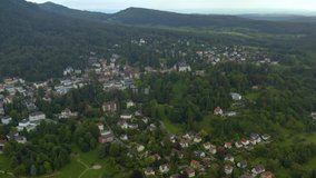 Aerial view of the city Badenweiler in Germany on a late cloudy day in summer.  Zoom out from the city.