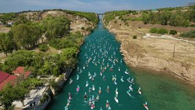Aerial bird's eye view video taken by drone of stand up paddle surfers in annual  crossing competition in Corinth Canal, Greece