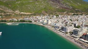 Aerial drone video of famous seaside area and main town of Loutraki with sandy organised beach with turquoise clear sea and resorts, Greece