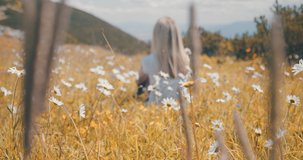 Happiness Woman tourist traveler sitting on meadow, top of mountain in summer, sunny day under sun light. 4K slow motion video