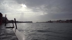 Dramatic cloudy sky above Venetian Lagoon in spring.Bad weather in Venice,Italy.Popular Italian landmark city of Venezia.Video filmed from Guidecca island in rainy day