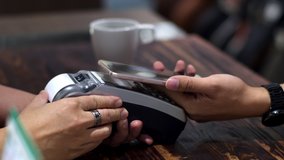 4K Locked shot with barista served black coffee and send the credit transaction to customer making contactless payment for paying by smartphone in coffee shop, NFC technology - Powered by Shutterstock - Get 15% off with code: PIKWIZARD15