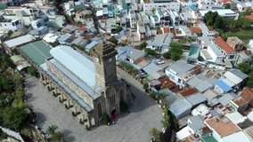 Aerial video footage of popular tourist destination of Nha Trang on the South Central Coast of Vietnam featuring the provincial, French Gothic style Nha Trang Cathedral, the largest church in the city
