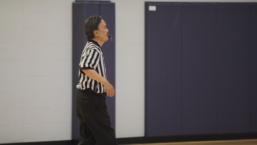 Asian Basketball Referee Running in Slow Motion with Whistle in Mouth