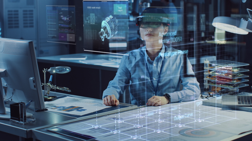 Industrial Factory Chief Engineer Wearing AR Headset Designs a Prototype of an Electric Motor on the Holographic Smart Blueprint. Futuristic Virtual Design of Mixed Technology Application. Royalty-Free Stock Footage #1037713625