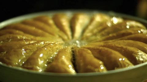 Pouring syrup into baklava, triangle slice