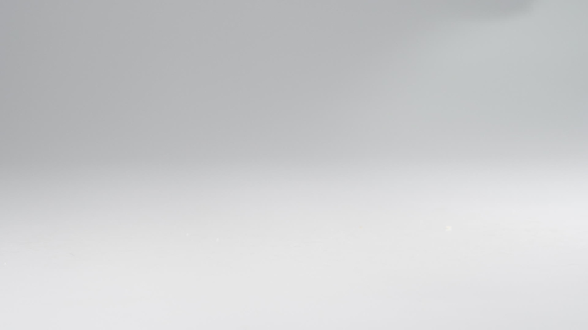 Healthy trail mix falling onto a white surface in slow motion