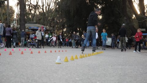 Rome, Italy - March 7, 2016: In the public park of Villa Borghese, some young people train with skates, on the skittle alley. Rollerblade skating on the paved track.