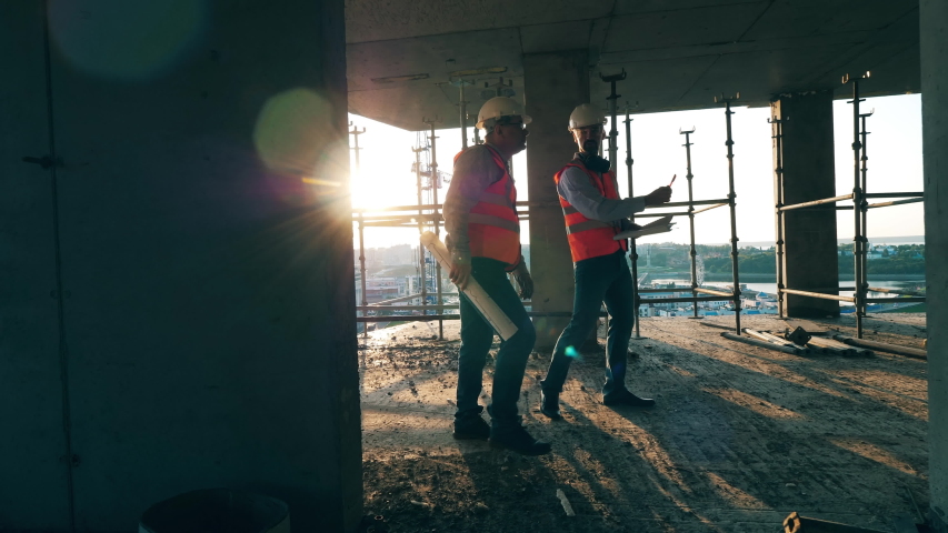 Construction workers are walking along the building in progress Royalty-Free Stock Footage #1037716772