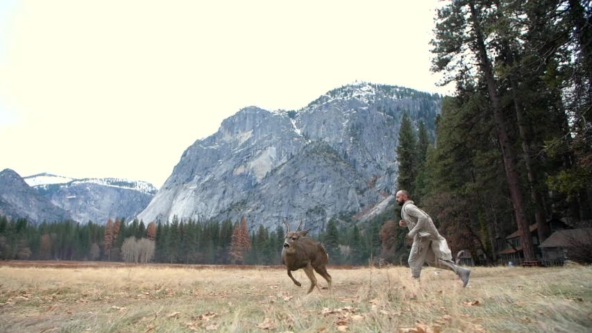 Man running with deers at Yosemite National Park.