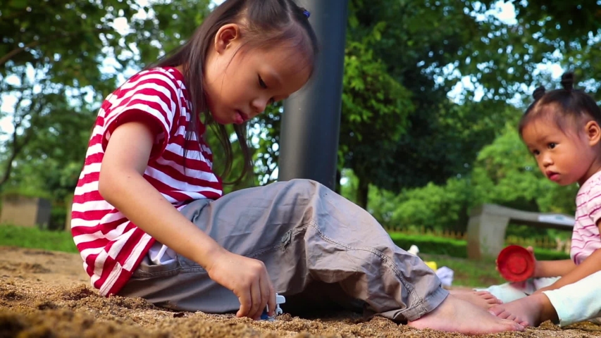 kids playing sand together , Funny Asian children family in a public playground.