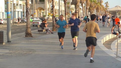 Tel aviv / Israel - 09 04 2019: People jogging running on a street near a beach in Tel Aviv, Izrael
