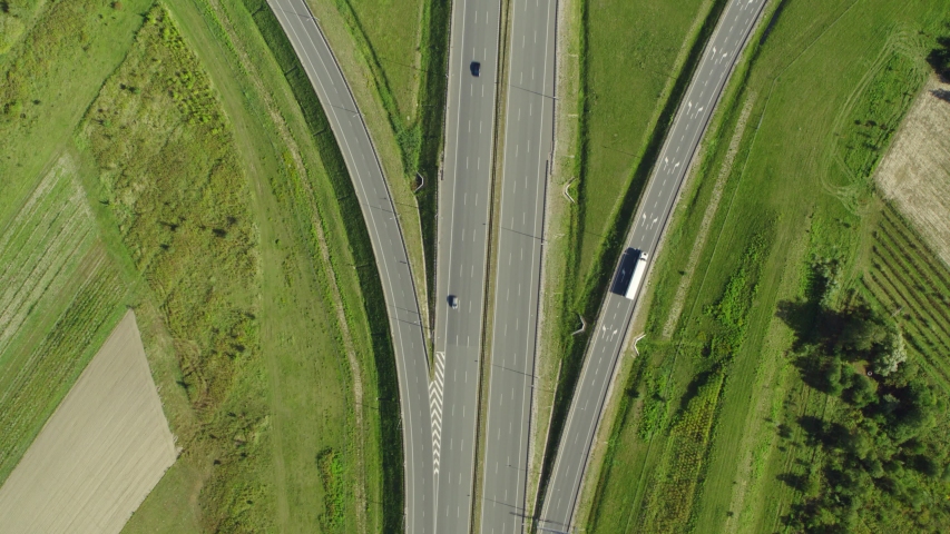 Aerial shot over evening road traffic. Highway and overpass with cars and trucks, interchange, two-level road junction. Aerial view, top down view of traffic jam on a car bridge. 4K video