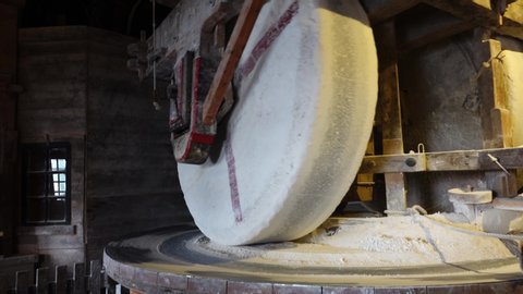 Zaandam Zaanse Schans near Amsterdan inside a typical dutch windmill large wooden wheels grinding peanuts automated process, by the wind on the blades outside the mill old industrial process 4k