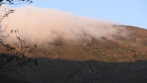 Condensed water in the form of clouds going over a hill in Petropolis, Rio de Janeiro, Brazil