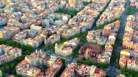 Barcelona / Spain - 08 23 2019: BARCELONA, SPAIN, AUGUST 23 - Aerial, tilt up, drone shot, revealing the La Sagrada familia cathedral, under construction, over the cityscape of Barcelona city, at suns